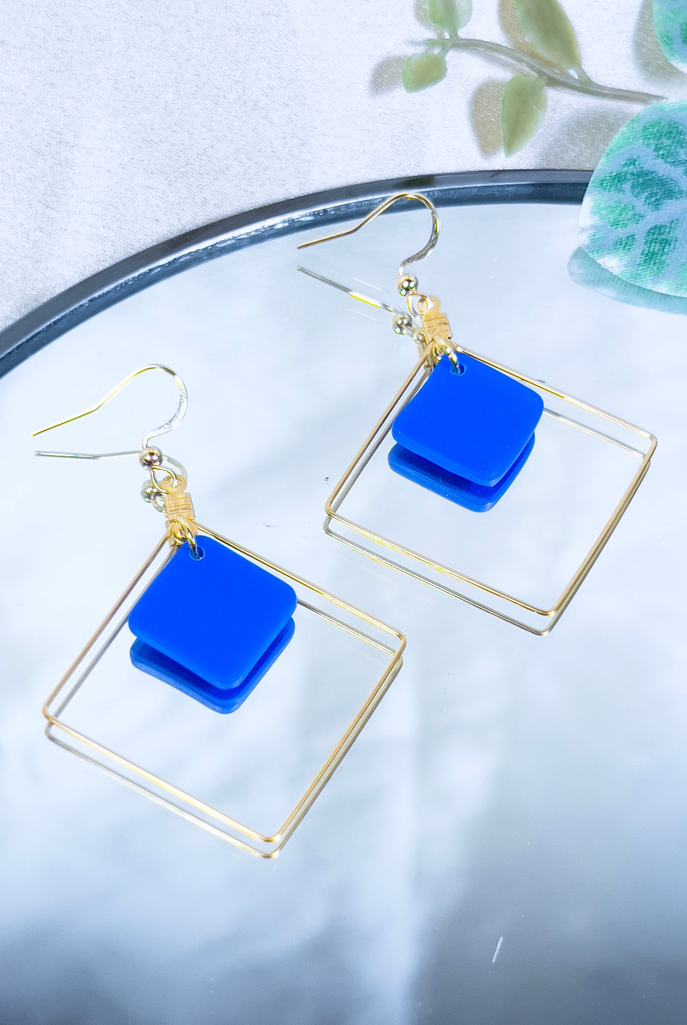 Boucles d'oreilles artisanales fantaisie, créoles carrée en acier inoxydable doré avec carré bleu suspendu à l'intérieur