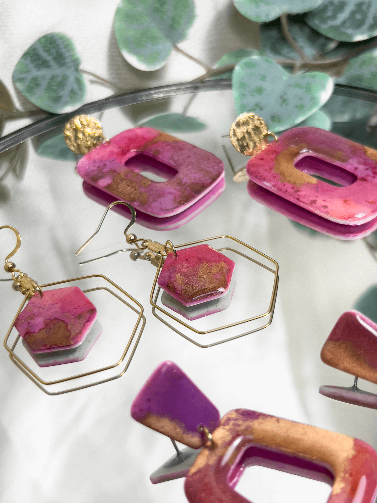 Bijoux fantaisie de créateurs. Boucles d'oreilles colorées de forme vintage. Couleur violet / rose et doré